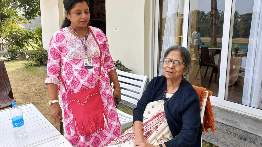 An Indian elderly woman speaking while a younger Indian woman listens.
